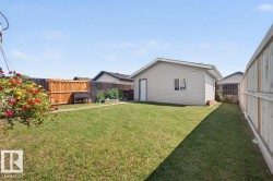 Detached garage with light-colored siding, a single window, and a service door - 