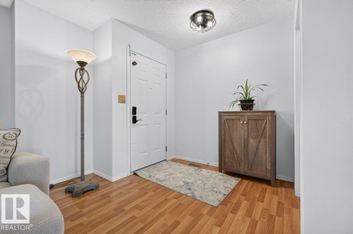 Entryway featuring wood-finish flooring, white paneled door, and a flush-mount ceiling light fixture - 17411 90 Street Nw, Edmonton, AB - Indoor Photo Showing Other Room