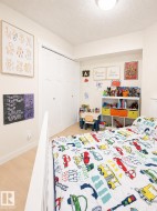 Room featuring wood-finish flooring, white walls, and a built-in closet with double sliding doors - 