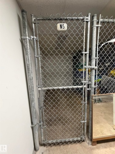 Chain-link storage enclosure with galvanized steel framing and a dedicated identifier - #101 11825 71 St Nw, Edmonton, AB - Indoor