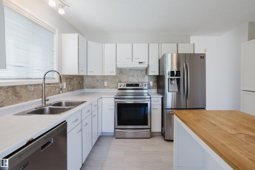 Modern kitchen featuring white cabinetry, light countertops, and a full suite of stainless steel appliances - 337 Pearson Crescent Nw, Edmonton, AB - Indoor Photo Showing Kitchen With Double Sink