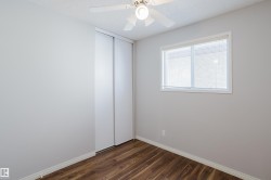 Bedroom featuring wood-finish flooring, white baseboards, and light gray walls - 