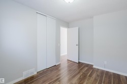Interior room featuring wood-finish flooring, light grey painted walls, and white trim - 