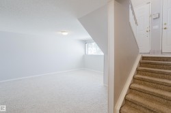 Lower-level living area featuring neutral carpeting and a semi-flush mount ceiling fixture - 