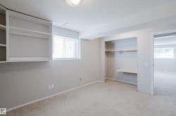 Room featuring built-in shelving, a window with blinds, and a built-in closet with a hanging rod and shelf - 