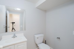 White vanity with integrated sink, chrome faucet, and a wall-mounted mirror - 