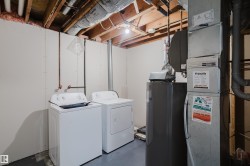 Dedicated utility room featuring a washer and dryer, water heater, and forced air furnace - 