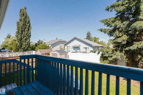 Deck with blue-painted wood railing and steps, overlooking a fenced backyard with green lawn - 337 Pearson Crescent Nw, Edmonton, AB - Outdoor