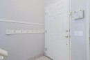 Entryway featuring a paneled door with brass hardware, tile flooring, a wall-mounted coat rack with brass hooks, and an alarm system keypad - 337 Pearson Crescent Nw, Edmonton, AB  - Indoor Photo Showing Other Room 