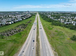 Aerial perspective showcasing a multi-lane highway bordered by green spaces and residential neighborhoods - 