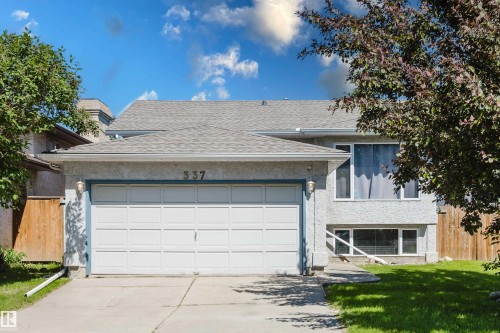Stucco exterior with a two-car garage, concrete driveway, and mature landscaping - 337 Pearson Crescent Nw, Edmonton, AB - Outdoor
