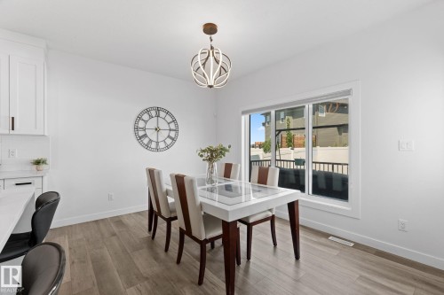 Dining area with wood-finish flooring, white walls, and a large window - 59 Willow Link, Fort Saskatchewan, AB - Indoor Photo Showing Dining Room