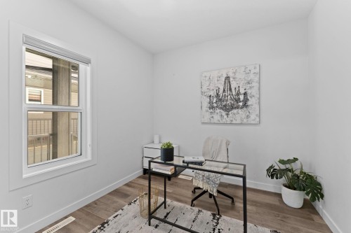 Room featuring wood-finish flooring, a white trim window, and white painted walls - 59 Willow Link, Fort Saskatchewan, AB - Indoor Photo Showing Office