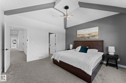 Vaulted ceiling featuring exposed beams, recessed lighting, a modern chandelier, and plush carpeting - 