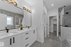Double vanity with white cabinetry, quartz countertops, and matte black hardware - 