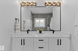 Dual vanity featuring white shaker-style cabinetry, quartz countertops, and matte black fixtures - 