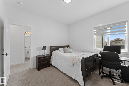 Light-filled room featuring a single window with blinds, neutral carpeting, and a doorway opening to an additional space - 59 Willow Link, Fort Saskatchewan, AB - Indoor Photo Showing Bedroom