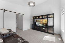Spacious room featuring a vaulted ceiling and light gray carpeting - 