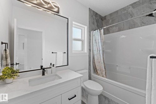 Bathroom featuring a white vanity with an integrated sink, quartz countertop, and matte black faucet - 59 Willow Link, Fort Saskatchewan, AB - Indoor Photo Showing Bathroom