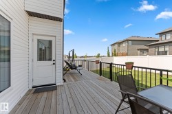 Spacious wood-finish deck with black metal railings - 