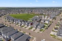 Aerial view of a residential neighborhood with numerous single-family homes featuring gray shingle roofs - 