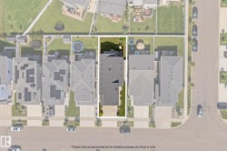 Aerial view showcasing the property's rectangular lot with a dark-pitched roofline, a manicured lawn, and a paved driveway - 