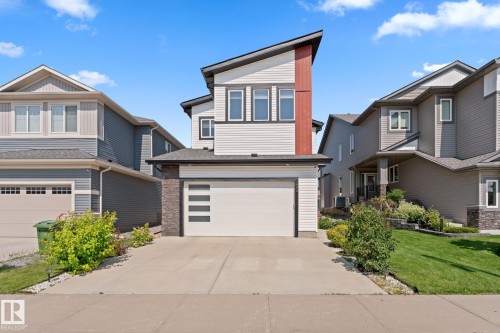 Contemporary exterior featuring contrasting siding, an integrated garage, a concrete driveway, and established landscaping - 59 Willow Link, Fort Saskatchewan, AB - Outdoor With Facade