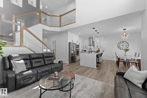 Expansive open-concept living area featuring wood-finish flooring, a contemporary kitchen, and a dining space - 59 Willow Link, Fort Saskatchewan, AB - Indoor Photo Showing Living Room