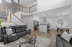 Expansive open-concept living area featuring wood-finish flooring, a contemporary kitchen, and a dining space - 