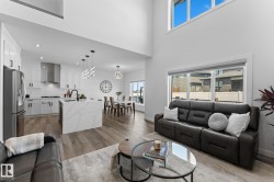 Open-concept living area featuring high ceilings and wood-finish flooring - 