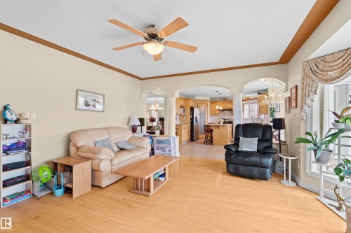 Spacious living area featuring wood-finish flooring, a ceiling fan, and decorative crown molding - 7622 168A Avenue, Edmonton, AB - Indoor Photo Showing Living Room