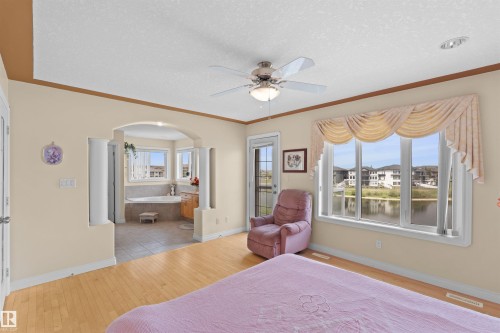 Light wood-finish flooring with a ceiling fan overhead - 7622 168A Avenue, Edmonton, AB - Indoor Photo Showing Bedroom