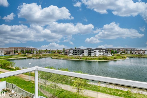 Balcony with clear glass railing overlooking a large pond and surrounding residential area - 7622 168A Avenue, Edmonton, AB - Outdoor With Body Of Water With View