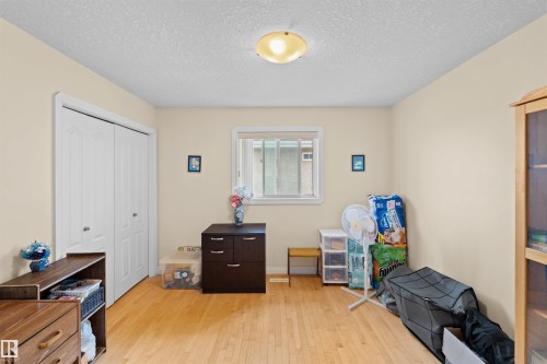 Room featuring wood-finish flooring, a double bi-fold closet, and a single window with white trim - 7622 168A Avenue, Edmonton, AB - Indoor