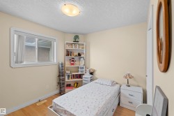 Light-toned walls complement wood-finish flooring in this room featuring a white-framed window and a flush-mount ceiling light - 