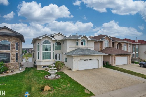 Two-story stucco exterior featuring a tiered fountain, arched and bay windows, a two-car garage, and an extended driveway - 7622 168A Avenue, Edmonton, AB - Outdoor With Facade