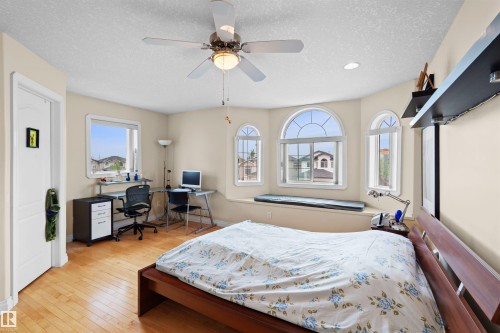 Bedroom featuring wood-finish flooring, a ceiling fan with integrated lighting, and a bay window seating area - 7622 168A Avenue, Edmonton, AB - Indoor Photo Showing Bedroom