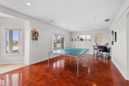 Spacious room featuring rich wood-finish flooring, recessed lighting, and white baseboards - 7622 168A Avenue, Edmonton, AB - Indoor Photo Showing Other Room