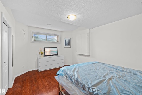 Room featuring wood-finish flooring, a white trim baseboard, and white painted walls - 7622 168A Avenue, Edmonton, AB - Indoor Photo Showing Bedroom
