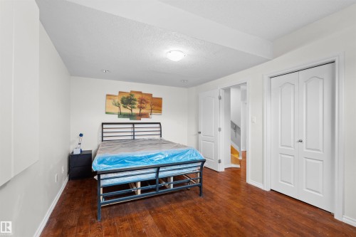 Spacious room featuring wood-finish flooring, white walls, and bright overhead lighting - 7622 168A Avenue, Edmonton, AB - Indoor