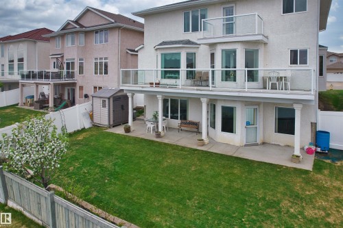 Rear exterior featuring a ground-level patio, upper-level balcony with glass railing, and a second-story balcony - 7622 168A Avenue, Edmonton, AB - Outdoor With Balcony