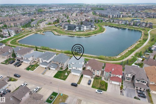 Aerial perspective showcasing a residential community with a central lake - 7622 168A Avenue, Edmonton, AB - Outdoor With Body Of Water With View