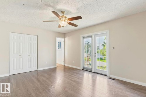 Room featuring wood-finish flooring, neutral wall paint, and a ceiling fan with integrated lighting - 10211 95 Ave, Morinville, AB - Indoor Photo Showing Other Room