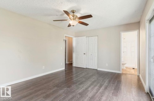 Spacious room featuring wood-finish flooring, light neutral wall paint, and a ceiling fan with integrated lighting - 10211 95 Ave, Morinville, AB - Indoor Photo Showing Other Room