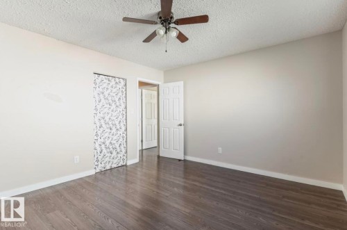 Room featuring wood-finish flooring, light-toned walls, and a ceiling fan with integrated lighting - 10211 95 Ave, Morinville, AB - Indoor Photo Showing Other Room