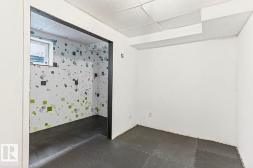 Interior room featuring white walls and dark gray interlocking floor tiles - 10211 95 Ave, Morinville, AB - Indoor Photo Showing Other Room