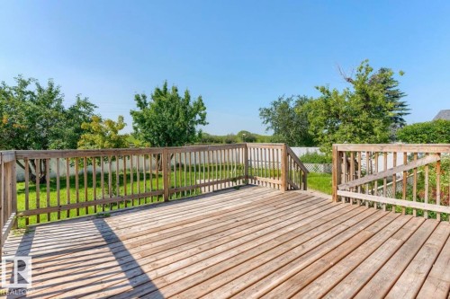 Expansive wooden deck featuring horizontal plank flooring and a full perimeter railing - 10211 95 Ave, Morinville, AB - Outdoor With Deck Patio Veranda