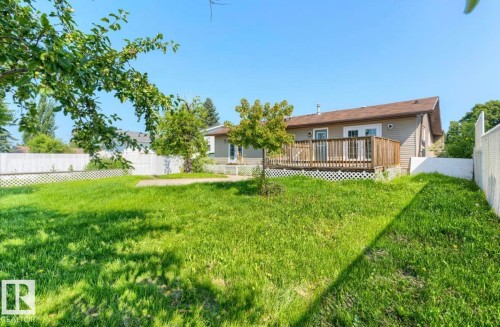 Expansive lawn area with a full privacy fence - 10211 95 Ave, Morinville, AB - Outdoor With Deck Patio Veranda