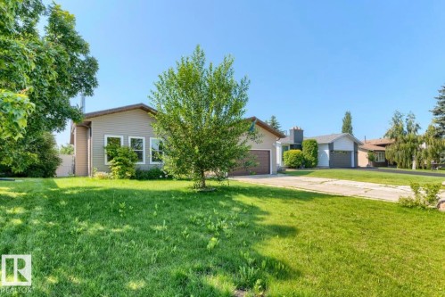 Ranch-style residence featuring light-colored siding, a brown roof, and a prominent front-facing window grouping - 10211 95 Ave, Morinville, AB - Outdoor