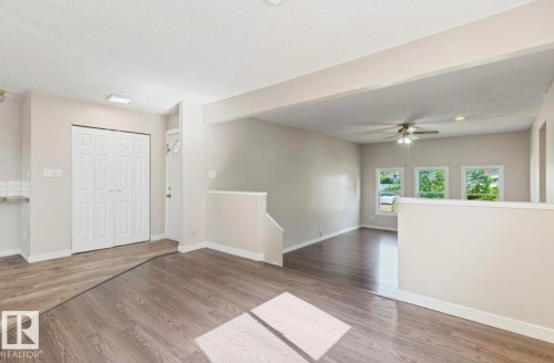 Open-concept living area featuring wood-finish flooring and neutral-toned walls - 10211 95 Ave, Morinville, AB - Indoor Photo Showing Other Room